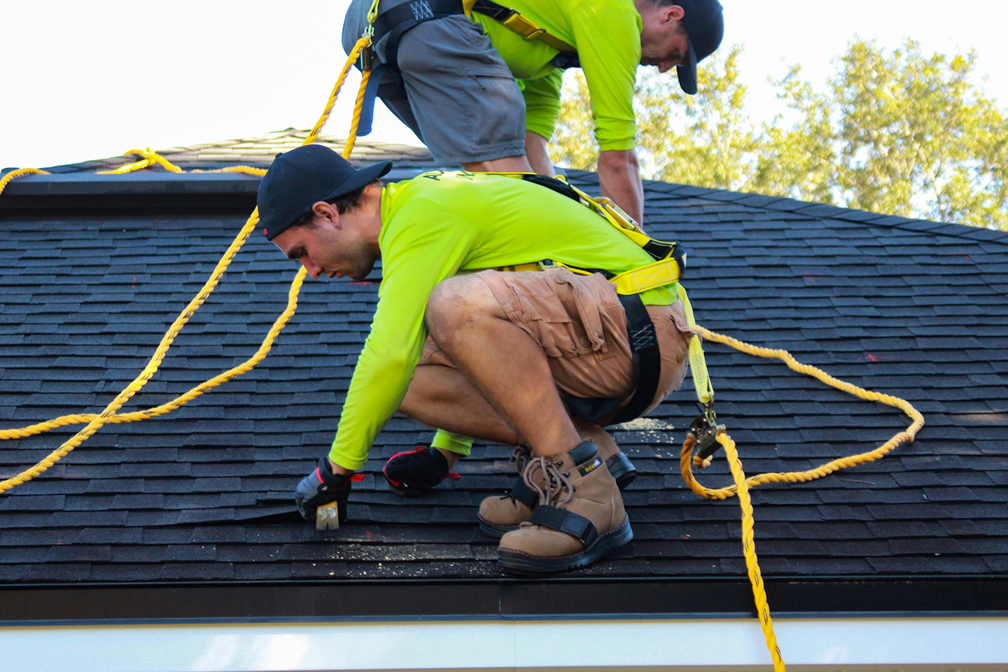 Roofing crew working on a roof tear-off job site documenting hidden damage for supplements